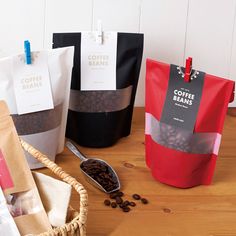 coffee beans are in bags next to a bag of coffee beans on a wooden table