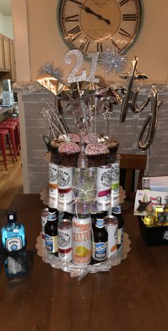 a table topped with lots of bottles of beer next to a large clock on the wall