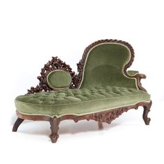 an antique chaise lounge chair with green velvet upholster and carved wood frame