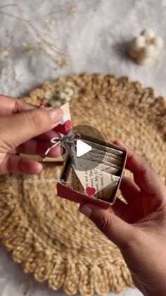 a person holding an open box with some type of food in it on a table