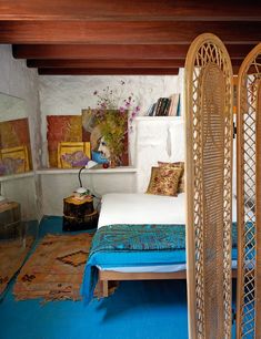 a bed room with a bed and a wooden frame on the wall next to a blue rug