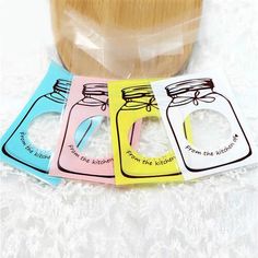 four different colored mason jars with labels on them