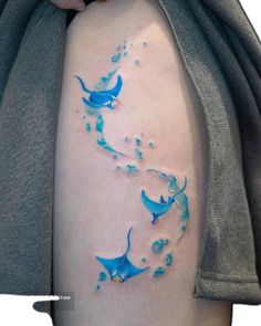 a woman's thigh with two blue birds on it