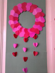 a door decorated with paper hearts and a wreath made out of the shape of a heart