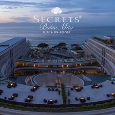 an aerial view of the resort and its parking lot at dusk with cars parked in front