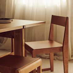 a wooden chair next to a table with a plate on it