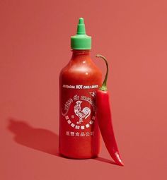 a red hot chili bottle next to a green pepper