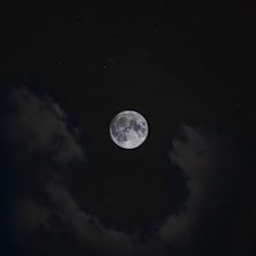 the full moon is visible in the dark night sky with clouds and stars around it