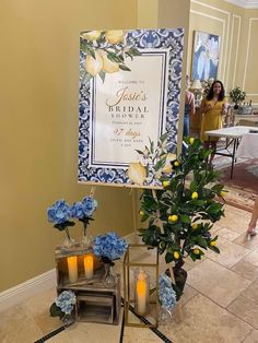 a sign that is on the ground with flowers and candles around it in front of a woman