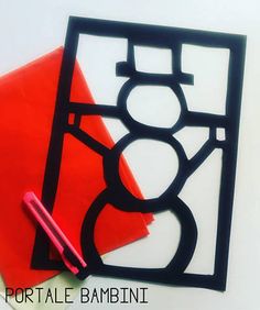 a red piece of paper sitting on top of a white table next to a marker