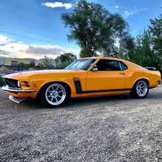 an orange muscle car parked in a parking lot