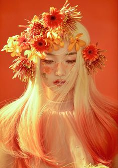 a woman with long blonde hair and flowers in her hair, wearing an orange flower crown