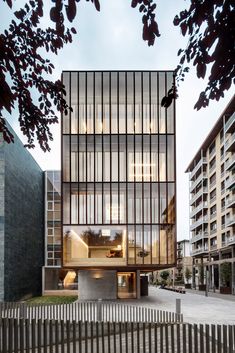 the building has many windows and is surrounded by tall buildings with wooden slats on each side