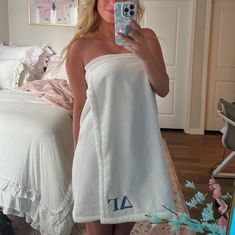 a woman taking a selfie in her bathroom towel