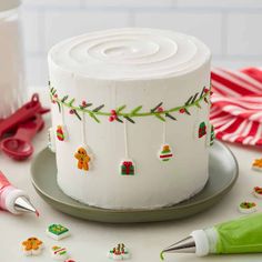 a white frosted cake sitting on top of a table next to scissors and other decorations