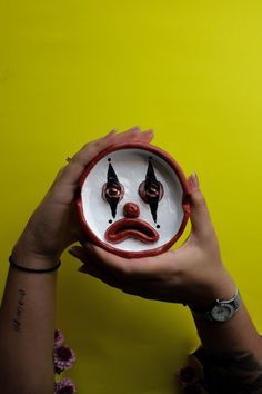 a person holding a plate with a face painted on it