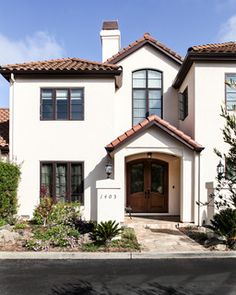 a large white house with two story windows and a brown door in front of it