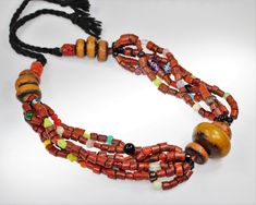 Traditional Ethnic Berber Necklace from Morocco with Faux Amber and faux (simulated) coral beads in the traditional Berber style. Those necklaces have been worn for weddings and other special occasions.  This necklace has 6 strand connected in the center by the focal amber bead. It is to be closed in the neck with a cord and therefore adjustable in lenght. Length 80 cm / 31,5 " open included the black cord. Weight 201 g Amber Beads, Coral Beads, Strand Necklace, Morocco, Amber, Coral, Jewelry Necklaces, Beads, Black