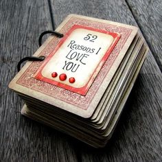 a stack of cards with the words 52 reasons i love you written on them, sitting on a wooden surface