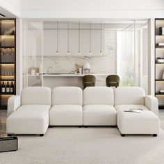 a large white couch sitting in a living room next to a kitchen and dining table