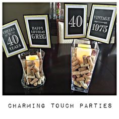 a table topped with vases filled with wine corks next to framed pictures and candles