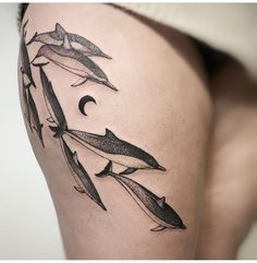 a woman's thigh with some dolphins on it