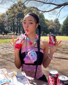 a woman in a bra top holding up two soda cans and an ice cream cone