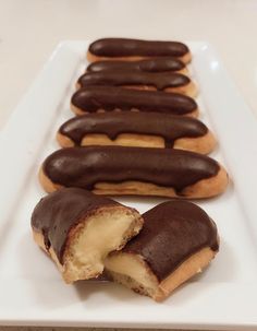 chocolate covered doughnuts are on a white plate