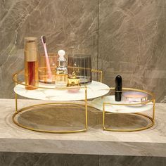 two trays with various items on them sitting on a marble counter top in front of a wall