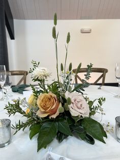 an arrangement of flowers on a white table cloth