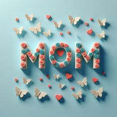 the word mom spelled out with butterflies and flowers on a blue background, surrounded by hearts