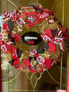 a football wreath with the number 19 on it and some red, white and black bows