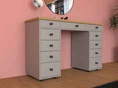 a desk with drawers and a mirror on the wall in front of pink painted walls