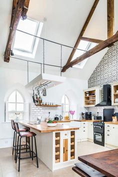 a kitchen with white walls and wooden beams