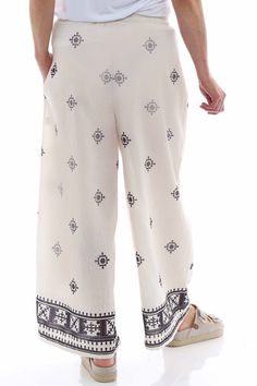 Get ready to elevate your style with our Fazara Print Trousers. These trousers feature an elasticated waistband with drawstring for the perfect fit, as well as a wide leg patterned design. Stay on trend and comfortable all day long in these fashionable trousers. - Wide leg - Drawstring waistband - Pockets Patterned Pants With Elastic Waistband For Vacation, Vacation Patterned Pants With Elastic Waistband, Casual Patterned Wide Leg Harem Pants, Patterned Vacation Bottoms, Casual Printed Cotton Wide Leg Pants, Patterned Relaxed Fit Bottoms With Elastic Waistband, Relaxed Fit Patterned Bottoms With Elastic Waistband, Patterned Long Pants For Vacation, Patterned Wide Leg Beach Bottoms