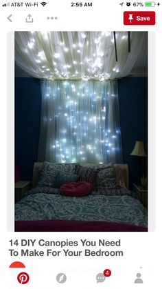 a bed with lights hanging from the ceiling in front of a curtained window over it