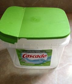 a green and white plastic container sitting on top of a counter next to a wall