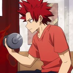 a man with red hair sitting down holding a dumbble weight machine in his hand