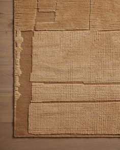 an area rug with squares and rectangles on top of wooden flooring in a room