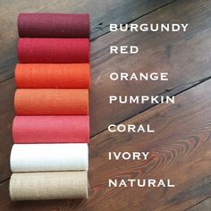 different colors of linens laid out on a wooden floor with the words burgundy red orange pumpkin coral ivory natural