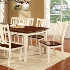 a dining room table with white chairs and brown wood top