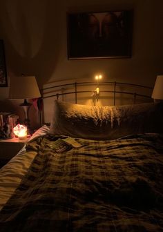 a bed with a plaid comforter and two candles on it