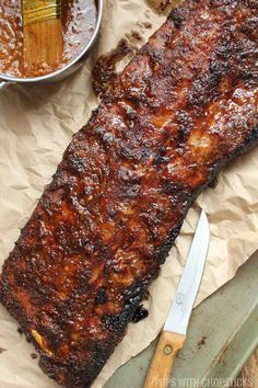 barbecue ribs on parchment paper with knife and sauce