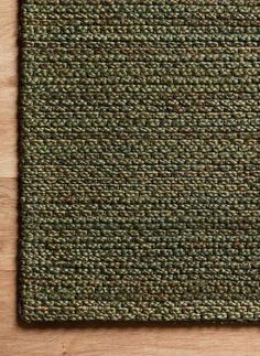 an area rug on top of a wooden floor with a brown and green color scheme