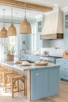 a kitchen with blue cabinets and wooden stools next to an island in the middle