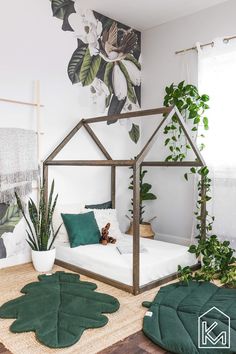 a bedroom with a bed, plant and rugs on the floor in front of it