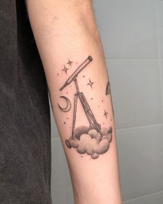 a man with a tattoo on his arm has a telescope and stars in the sky