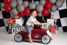 a young boy riding on top of a red toy car