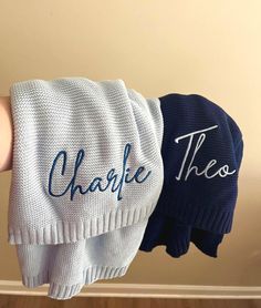 two hand towels with the words, charlie and thomas written on them are held up by someone's arm