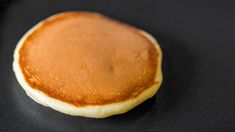 a close up of a pancake on a black surface